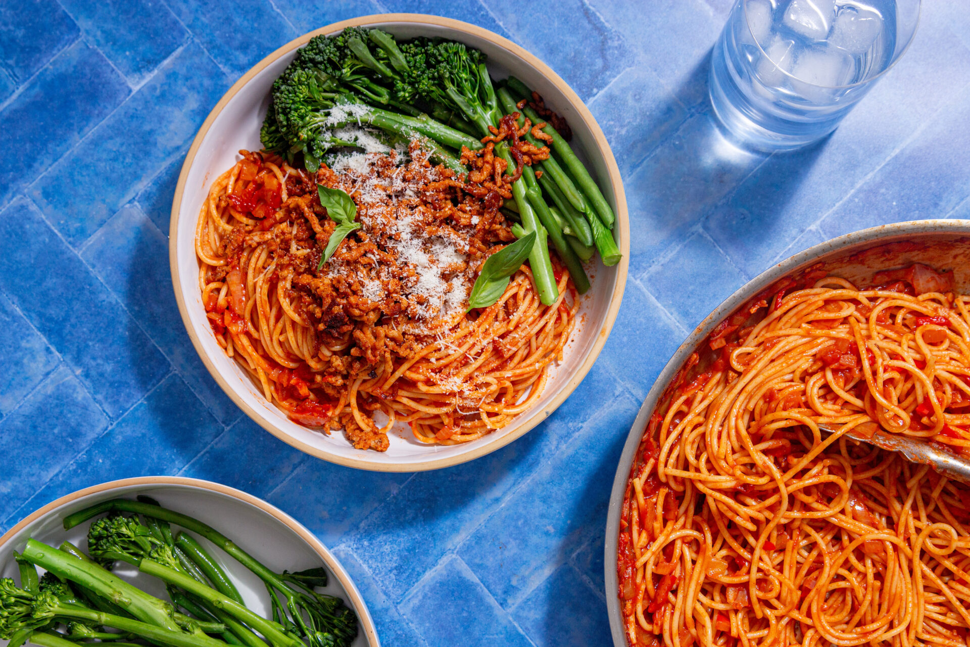 Spaghetti Arrabiata with Crispy Paprika Pork in a bowl next to a bowl of broccoli