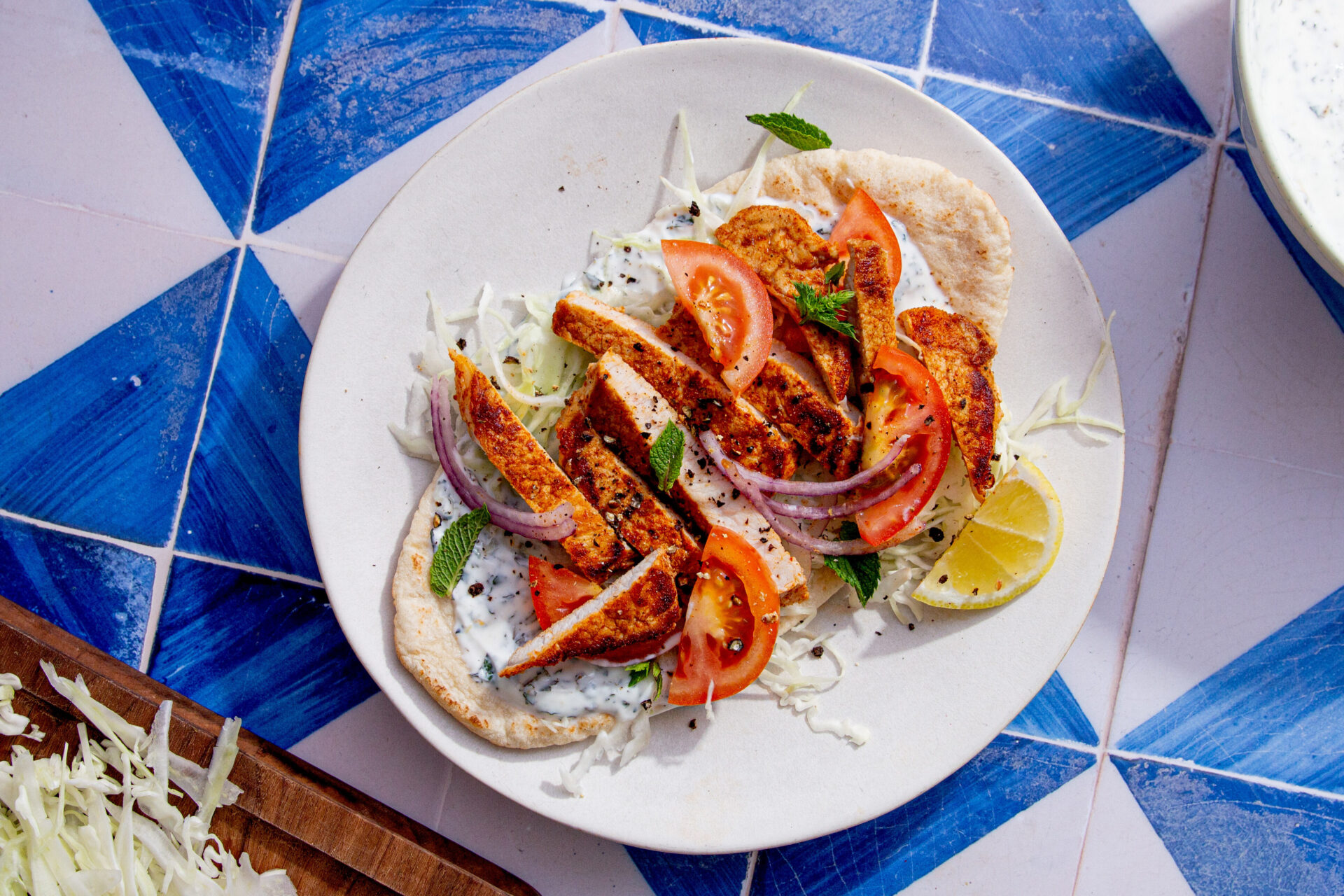 A pitta filled with vegetables and pork loin steak slices.