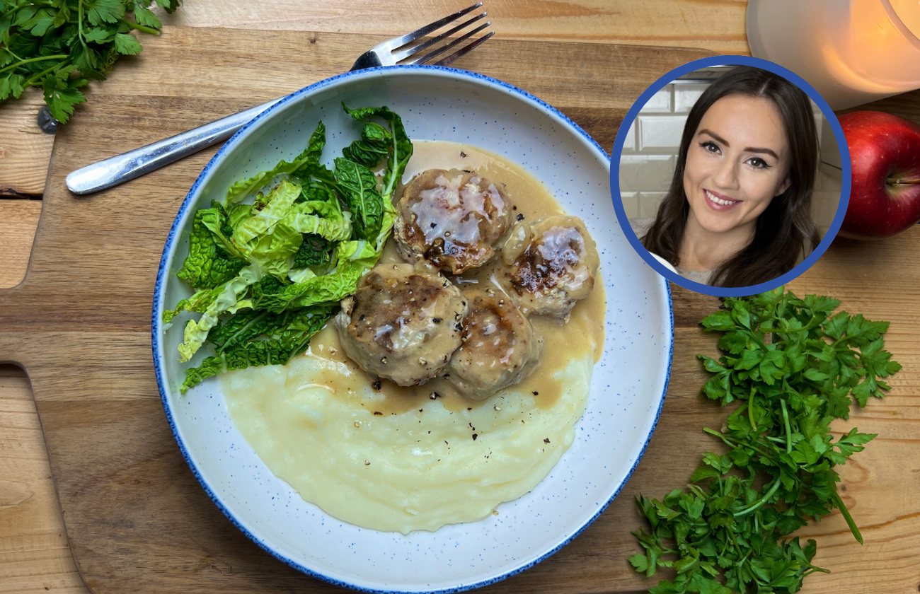 A plate of Juicy Pork and Apple Meatballs with potato mash and greens on the side.