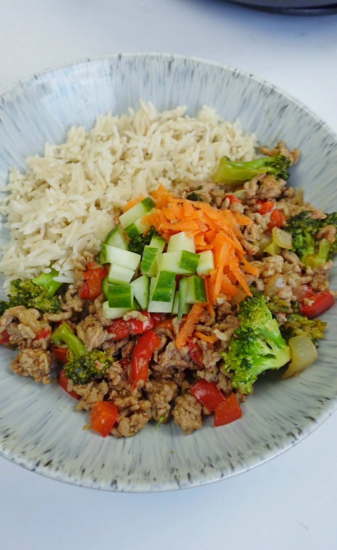 A plate of pork hoisin stir fry with rice and vegetables