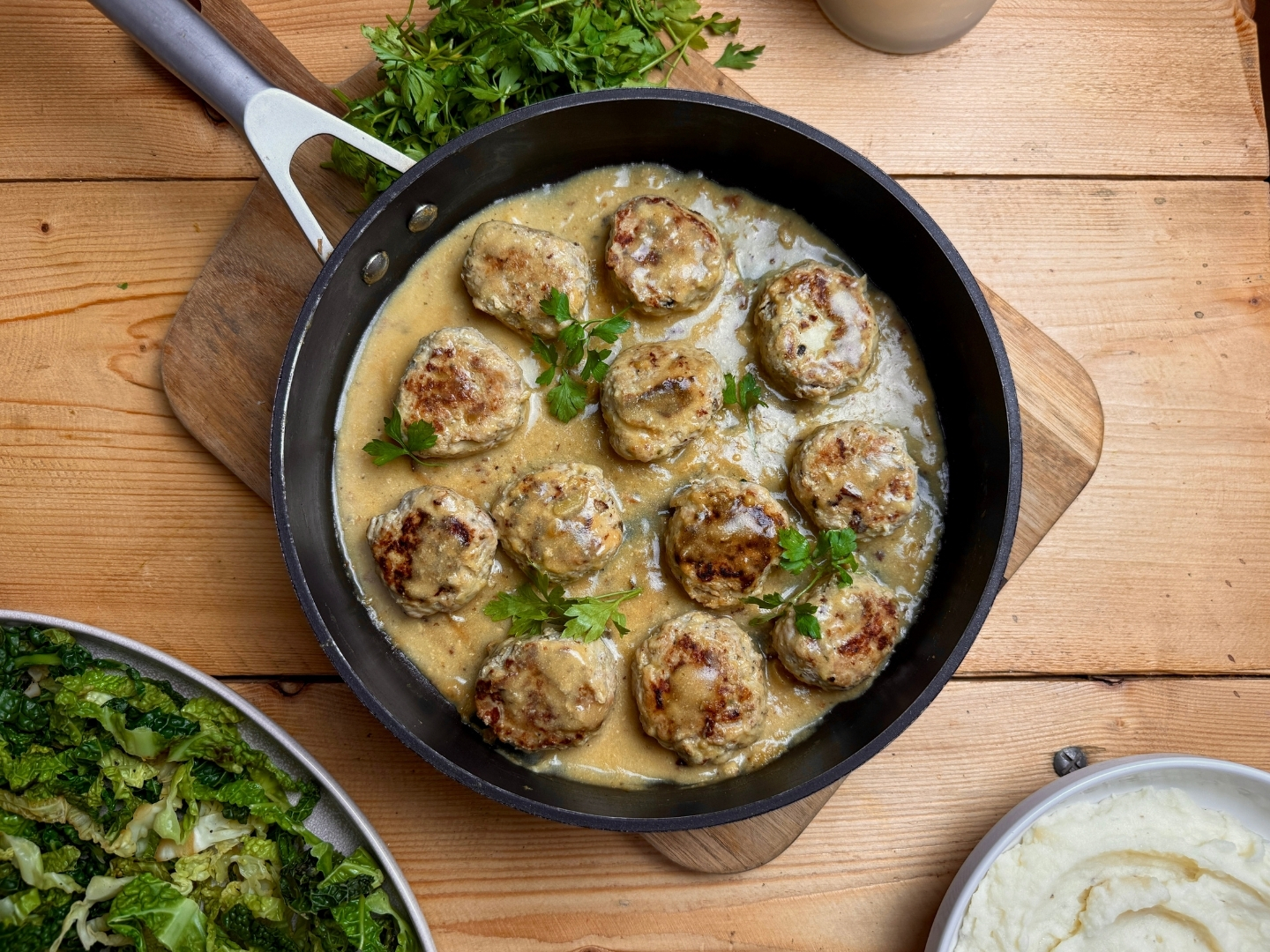 A pan of juicy pork and apple meatballs with mash