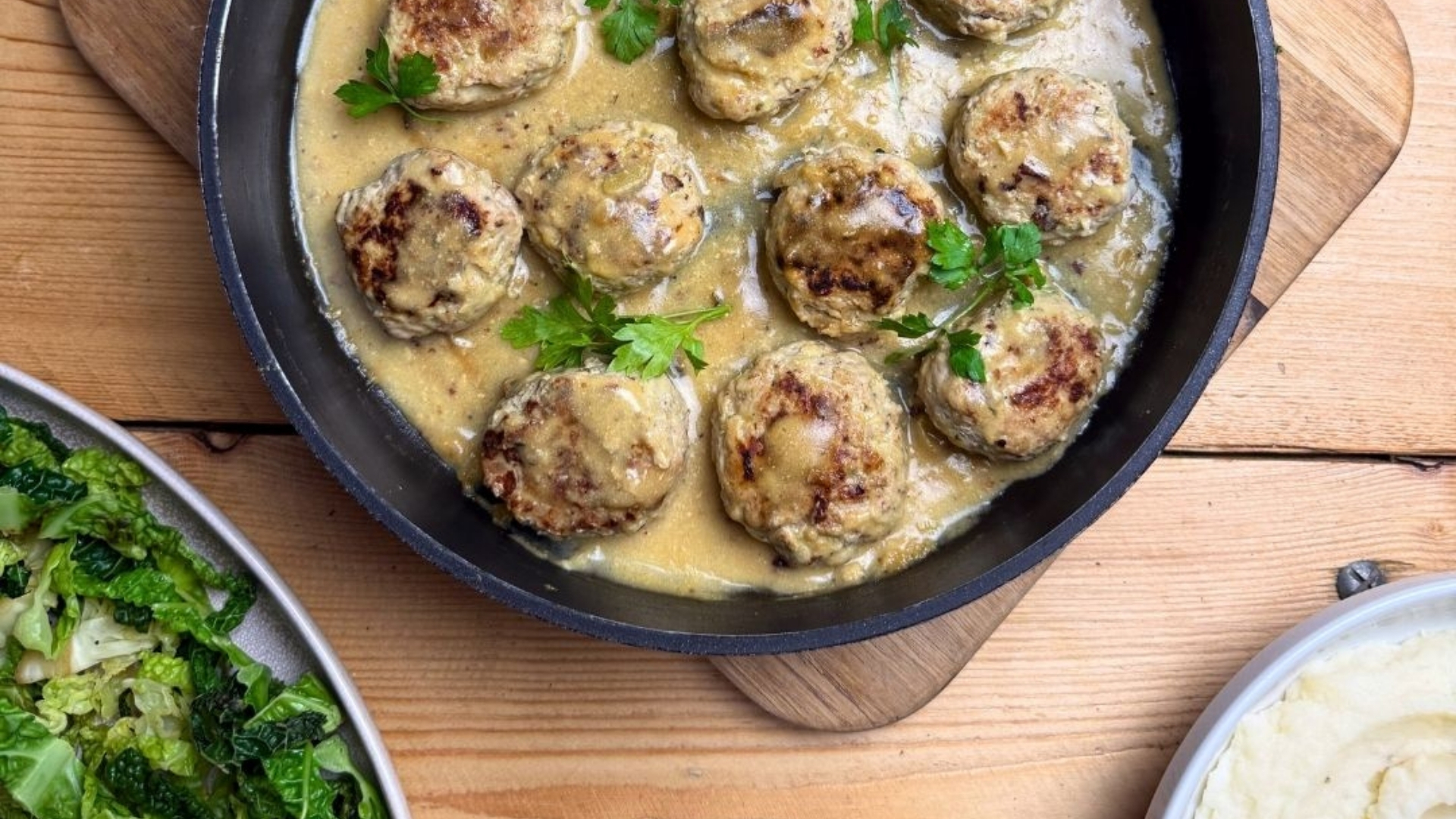 A pan of juicy pork and apple meatballs with mash